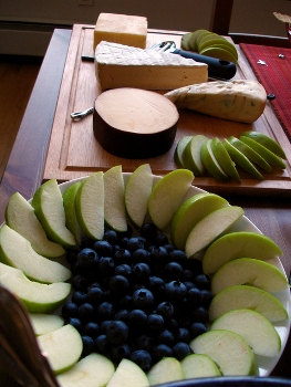 This photo of a fruit and cheese board being prepared was taken by an unidentified photographer. 
